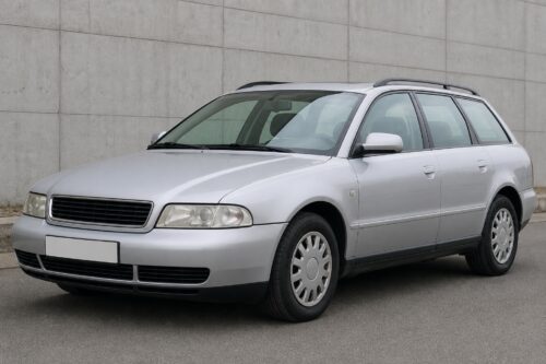 Silver station wagon parked by a concrete wall